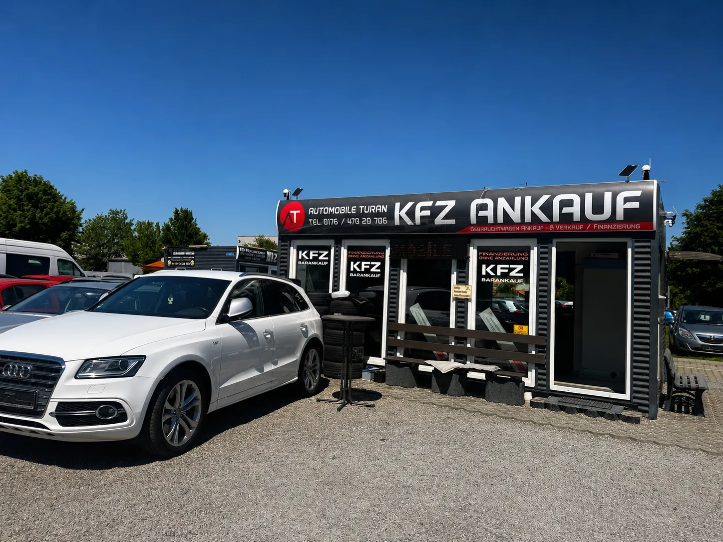 Weißer Audi Q5 vor dem beschrifteten Verkaufscontainer von Automobile Turan in Augsburg