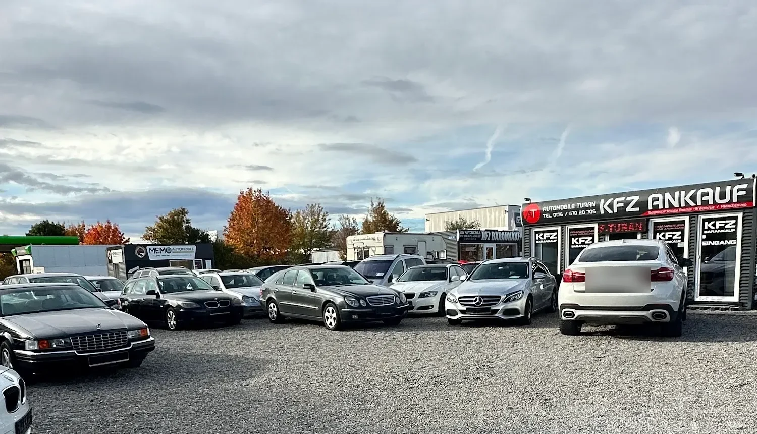 Weitblick über den Verkaufsplatz von Automobile Turan in Augsburg mit vielen Fahrzeugen und Container